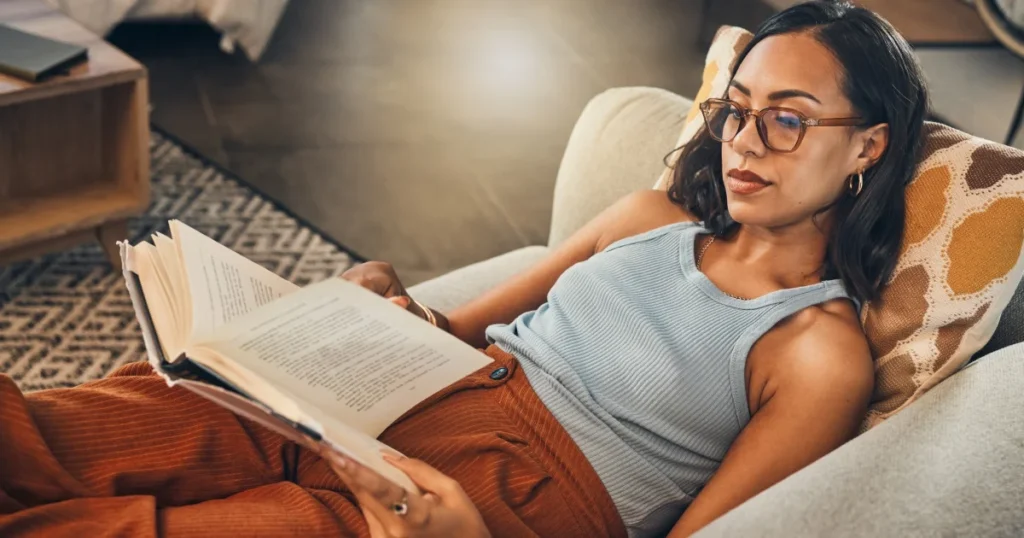 mulher lendo um livro no sofá