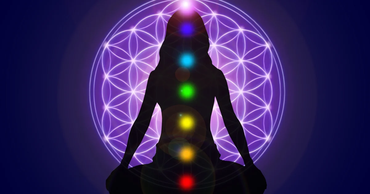 figura humana em postura de meditação com representação de 7 chakras